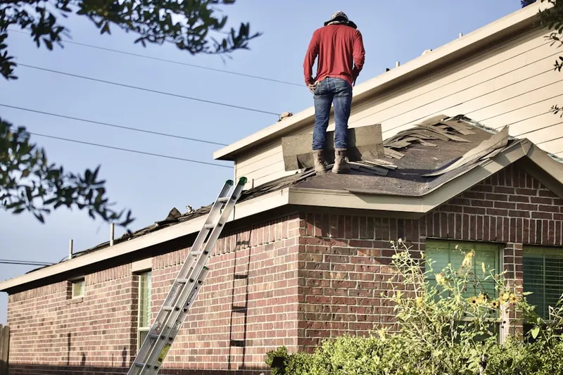 Professional roofer working on a residential roof in Harveysburg